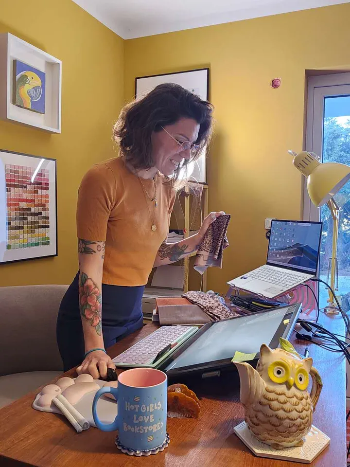 Èlia Barriga Polo standing at her studio desk with fabric swatches