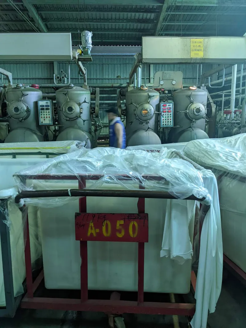 Factory floor with textile finishing machines and fabric in development